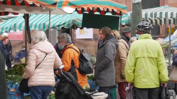 Kehl, Tyskland - 29 oktober 2021: Folk kom till den lokala jordbruksmarknaden för att köpa olika jordbruksprodukter. Vissa besökare bär medicinska masker, andra inte — Stockvideo