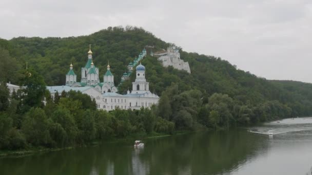 Святогорская Лавра, Донецкая область, Украина. Красивый старинный монастырь расположен в долине реки Северский Донец на горе вокруг зеленой листвы деревьев — стоковое видео