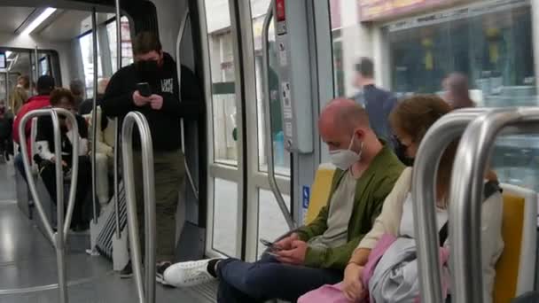 STRASBOURG, FRANCE - MAY 23, 2021: People ride on a city tram or train wearing protective masks against the pandemic, covid 19 sars — ストック動画