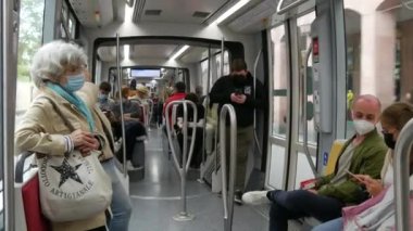 STRASBOURG, FRANCE - 23 Mayıs 2021: İnsanlar salgına karşı koruyucu maskeler takarak şehir tramvayına veya trene biniyor.
