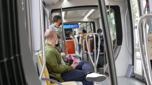 STRASBOURG, FRANCE - MAY 23, 2021: People ride on a city tram or train wearing protective masks against the pandemic, covid 19 sars — ストック動画