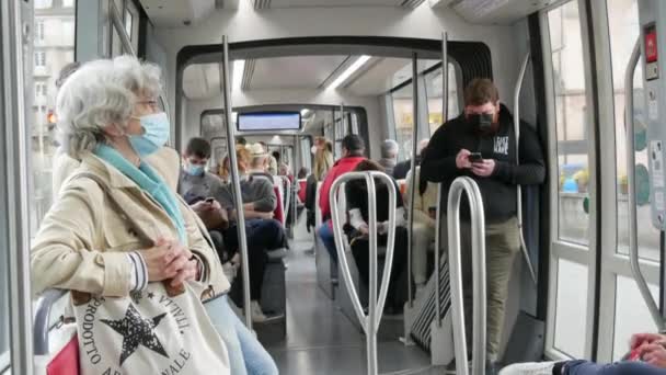 STRASBOURG, FRANCE - MAY 23, 2021: People ride on a city tram or train wearing protective masks against the pandemic, covid 19 sars — ストック動画