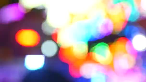 Avsiktligt suddig film av flerfärgat ljus från attraktionerna. Bokeh ljus på natten — Stockvideo