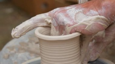 Çömlekçi elleriyle kaplanmış çömlekçi atölyesinde çark yapmak için çok güzel vazo yapıyorlar. Yaratıcılık ve geleneksel zanaat konsepti
