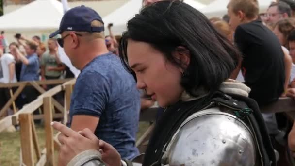 Trostyanets, Ukraine - 21 août 2021 : Les spectateurs regardent avec intérêt la reproduction de la bataille médiévale. Femme vêtue d'armure chevaleresque et de casques et boucliers métalliques se battent avec de l'acier froid — Video