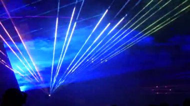 Gece gökyüzünün siyah arka planında hafif lazer gösterisi, açık hava gösterisi. Çok renkli lazer ışınları çeşitli şekillere dönüşür, dumandaki yansıma. Bilgi Teknolojisi Konferansı.