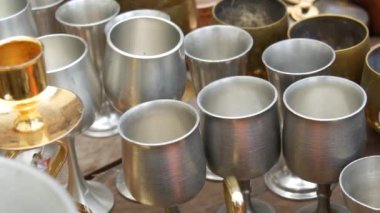 Bir sokak pazarındaki tezgahın tezgahında çok sayıda yeni ve çeşitli bakır kap kacak var. Kase, kase, tencere ve tava.