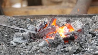 Medieval method of forging iron, the blacksmith forges an iron nail from the fire. Blacksmith is using hammer to forge metal