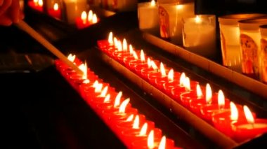 Row of lit burning red round candles in the cathedral. Religious candles for the rest of the soul in the catholic church.