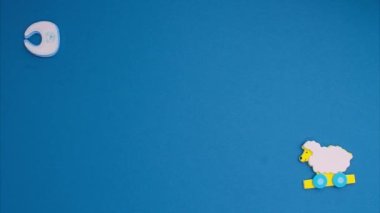 Funny blue stickers, symbolizing a newborn boy, appear on a blue background. Stop motion animation cartoon.