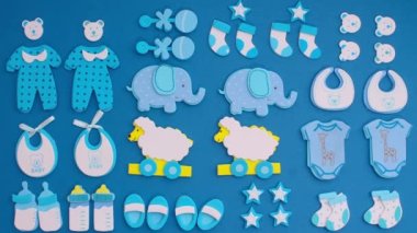 Funny blue stickers, symbolizing a newborn boy, appear on a blue background. Stop motion animation cartoon.