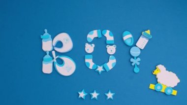 Funny blue stickers, symbolizing a newborn boy, appear on a blue background. Stop motion animation cartoon.