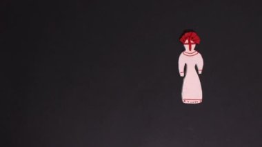 Claymotion hareketsiz animasyon ya da çizgi film. Plastik geleneksel Ukrayna motanka bebekleri ve renkli kurdeleli bir çiçek çelengi siyah bir arkaplanda görünür..