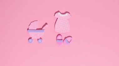 Funny pink stickers, symbolizing a newborn girl, appear on a pink background. Stop motion animation cartoon.