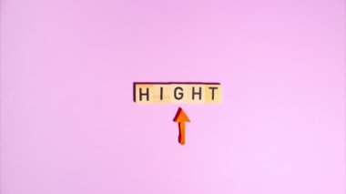 Plasticine stop motion animation. Wooden letters spell out the word hight, a plasticine red arrow appears and flickers on a purple background.