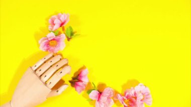 Stop motion animation. Wooden letters spell out the word spring, Wooden hand and yellow background