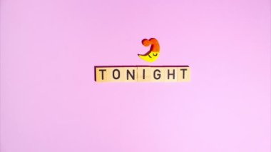 Plasticine stop motion animation. Wooden letters lay out the word at tonight, a plasticine month in a sleeping cap appears and disappears on a purple background.