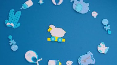 Funny blue stickers, symbolizing a newborn boy, appear on a blue background. Stop motion animation cartoon.