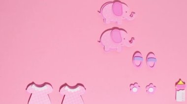 Funny pink stickers, symbolizing a newborn girl, appear on a pink background. Stop motion animation cartoon.