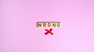 Plasticine stop motion animation. Wooden letters spell out the word wrong, a plasticine red cross appears and flickers on a purple background.