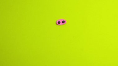 A funny pink plasticine pig in stop motion animation technique appears on a green background. Plasticine cartoon. Claymotion on the green background.