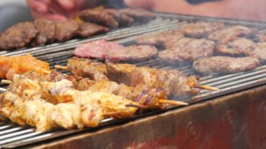 Pieces of fresh meat are grilled on a grill at a street food festival. Non vegetarian food, meat eaters.