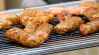 Pieces of fresh meat are grilled on a grill at a street food festival. Non vegetarian food, meat eaters close up view.