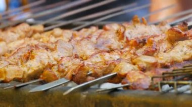 Pieces of fresh meat are grilled on a grill at a street food festival. Non vegetarian food, meat eaters close up view.