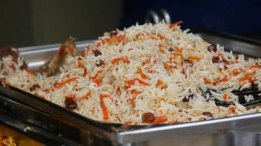 A large dish of rice is being prepared at an open air outdoor food festival.