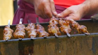 Pieces of fresh meat are grilled on a grill at a street food festival. Non vegetarian food, meat eaters close up view.