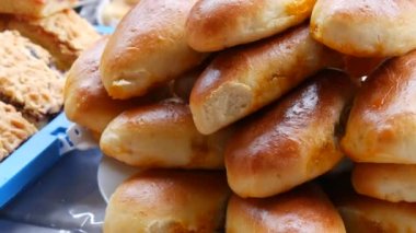 Freshly baked ready made pies on a tray at a street food festival. Homemade baking.