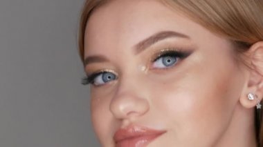 Şık bir akşamda güzel bir genç kız modelinin portresi dumanlı gözler, güzel altın bir göz farı ve dudaklarında ince bir ruj. Gözler yakın görünüm.