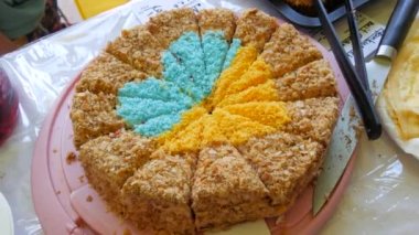 Homemade cakes, freshly baked biscuit cake honey cake with a beautifully laid out heart in the form of symbolic blue-yellow colors of the flag of Ukraine on the market counter at the fair.
