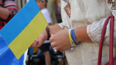 Blue-yellow flags of Ukrainians in the hands. People in national Ukrainian embroidered vyshyvanka costumes hold flags in their hands at a demonstration rally in support of Ukraine.