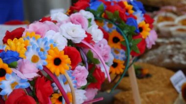 Lots of beautiful varied floral wreaths on the head. Traditional decoration of Ukraine on the counter of the market.