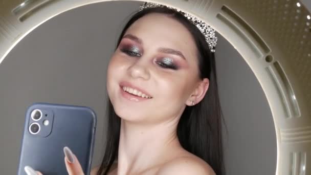 2021年3月23日 乌克兰卡门斯科奥 年轻美丽的女模特头戴皇冠 手里拿着智能手机摆姿势 — 图库视频影像