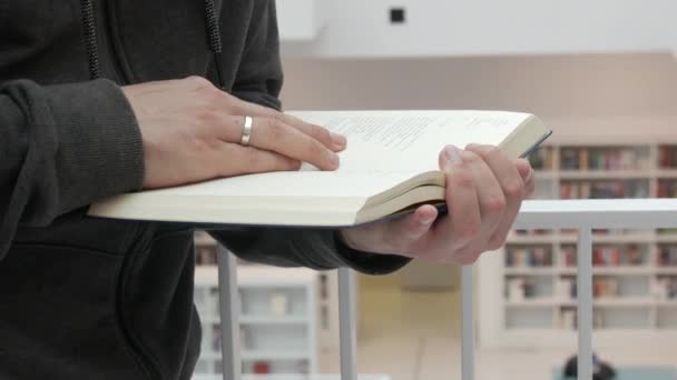 Hands Man Holding Book Bookstore Library Background Many Different Bookshelves — Vídeo de stock