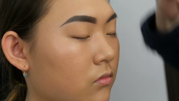 Professionell Makeup Artist Målar Ögonbryn Ansiktet Asiatisk Koreansk Kvinna Modell — Stockvideo
