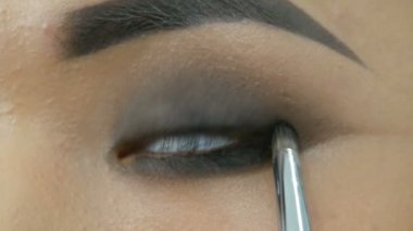 Profesyonel makyöz, Koreli Asyalı bir kızın özel fırçasıyla göz makyajı yapıyor.