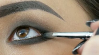 Profesyonel makyöz, Koreli Asyalı bir kızın özel fırçasıyla göz makyajı yapıyor.