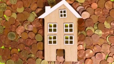 Stop motion animation, euro coins on a green background move around and next to a wooden house. money and cartoon.