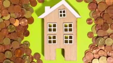 Stop motion animation, euro coins on a green background move around and next to a wooden house. money and cartoon.