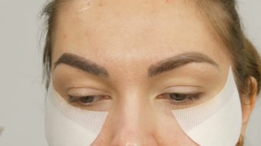 Makyaj sanatçısı, model kızları güzellik salonunda profesyonel makyaj malzemesi yapar. Özel bir fırçayla kaş çizimi