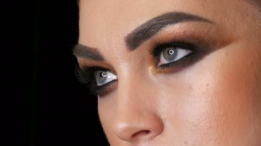 Stüdyoda kameranın önünde poz veren şık dumanlı göz makyajlı güzel bir profesyonel kız modelinin yüz portresi. Yüksek moda.