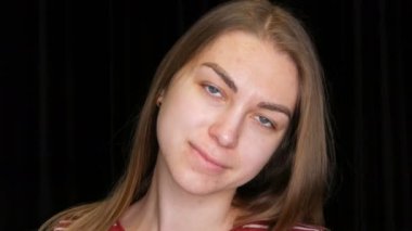 Güzel, uzun saçlı, sorunlu bir kız kameranın önünde poz veriyor.