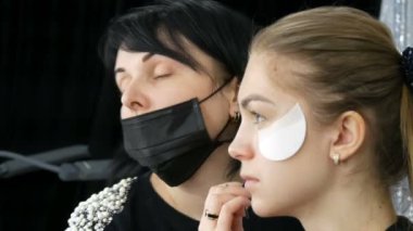 Makyaj sanatçısı, model kızları güzellik stüdyosunda profesyonel moda dumanlı göz makyajı yapar.