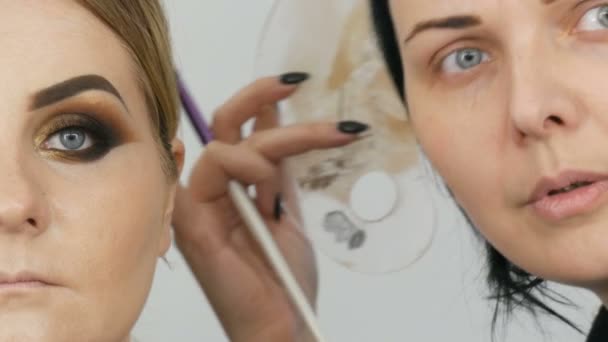 2019年4月7日 乌克兰卡门斯科奥 化妆大师在美容院将专业的金色烟熏眼睛涂到蓝眼睛模特身上 — 图库视频影像