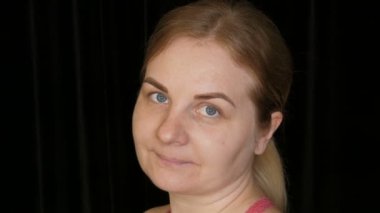 Siyah bir arka planda, çilli, sarı saçlı ve mavi gözlü muhteşem bir kadının portresi..