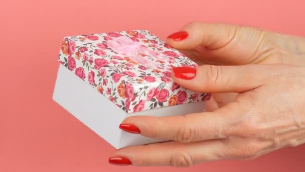 Ένα Μικρό Κουτί Δώρου Floral Αποτύπωμα Και Ένα Ροζ Τόξο — Αρχείο Βίντεο