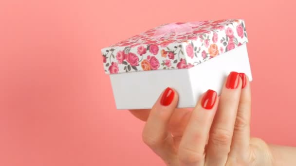 Невелика Подарункова Коробка Квітковим Принтом Рожевим Бантом Який Тримають Руки — стокове відео
